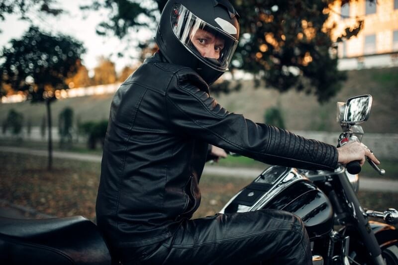 Biker in helmet poses on a motorcycle